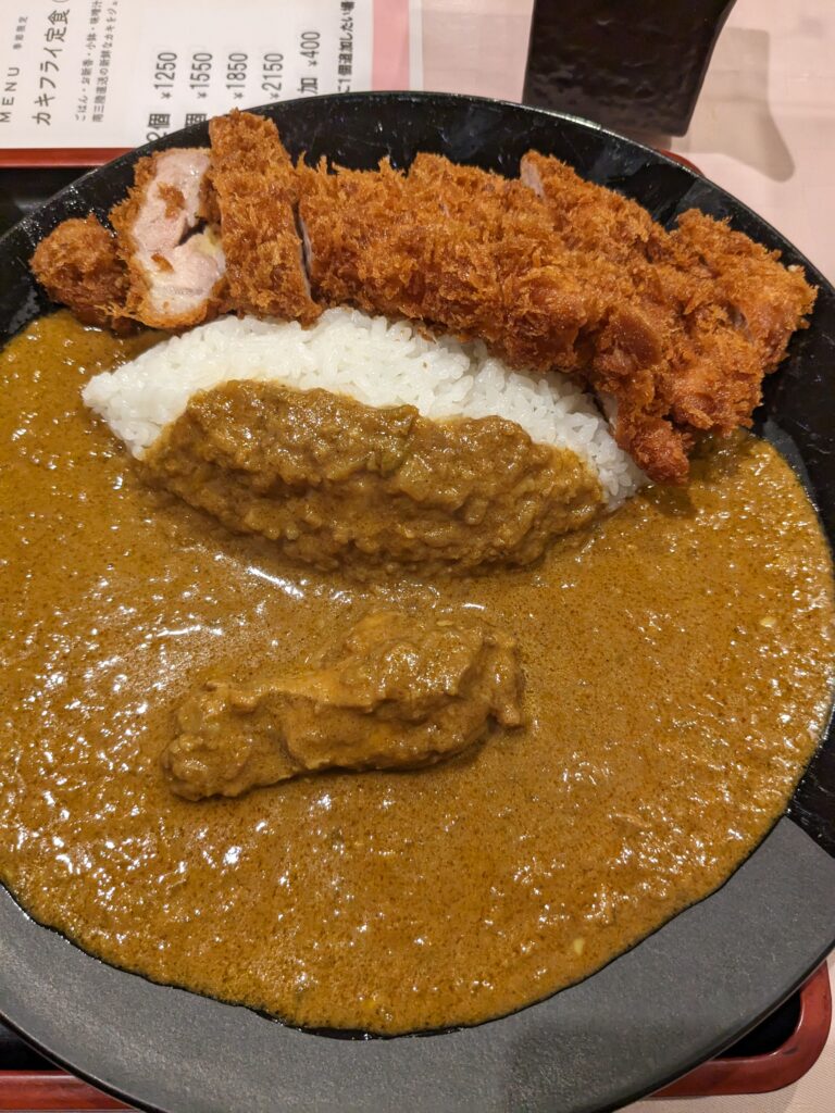 三幸のカツカレーを真上から撮影。ごはんの上に大きなカツが並び、ルーがたっぷりかかっている