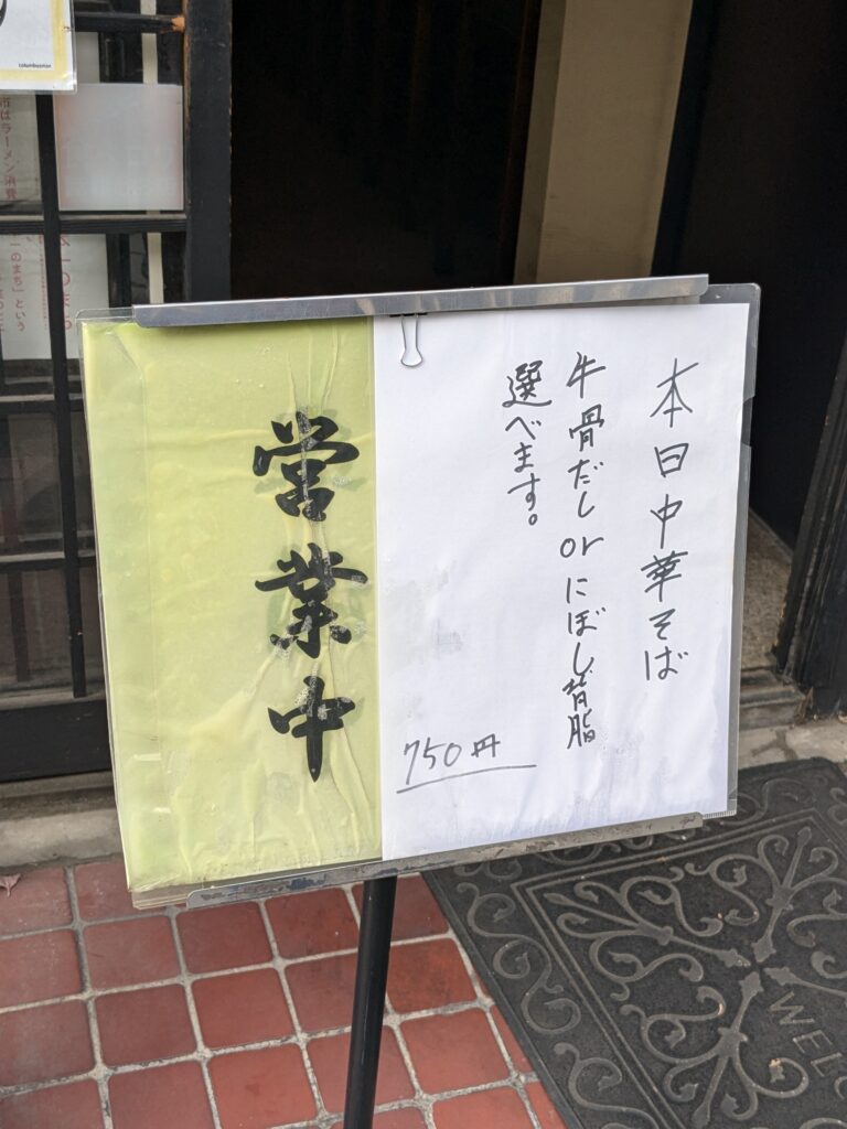 店頭に掲示された案内ボード。本日の中華そばは「牛骨だし」または「にぼし背脂」から選択可。