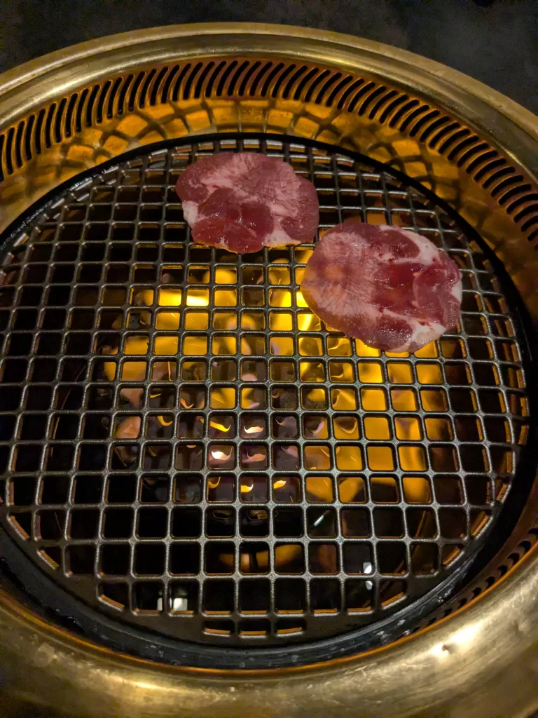 炭火で焼かれる牛タン2枚
