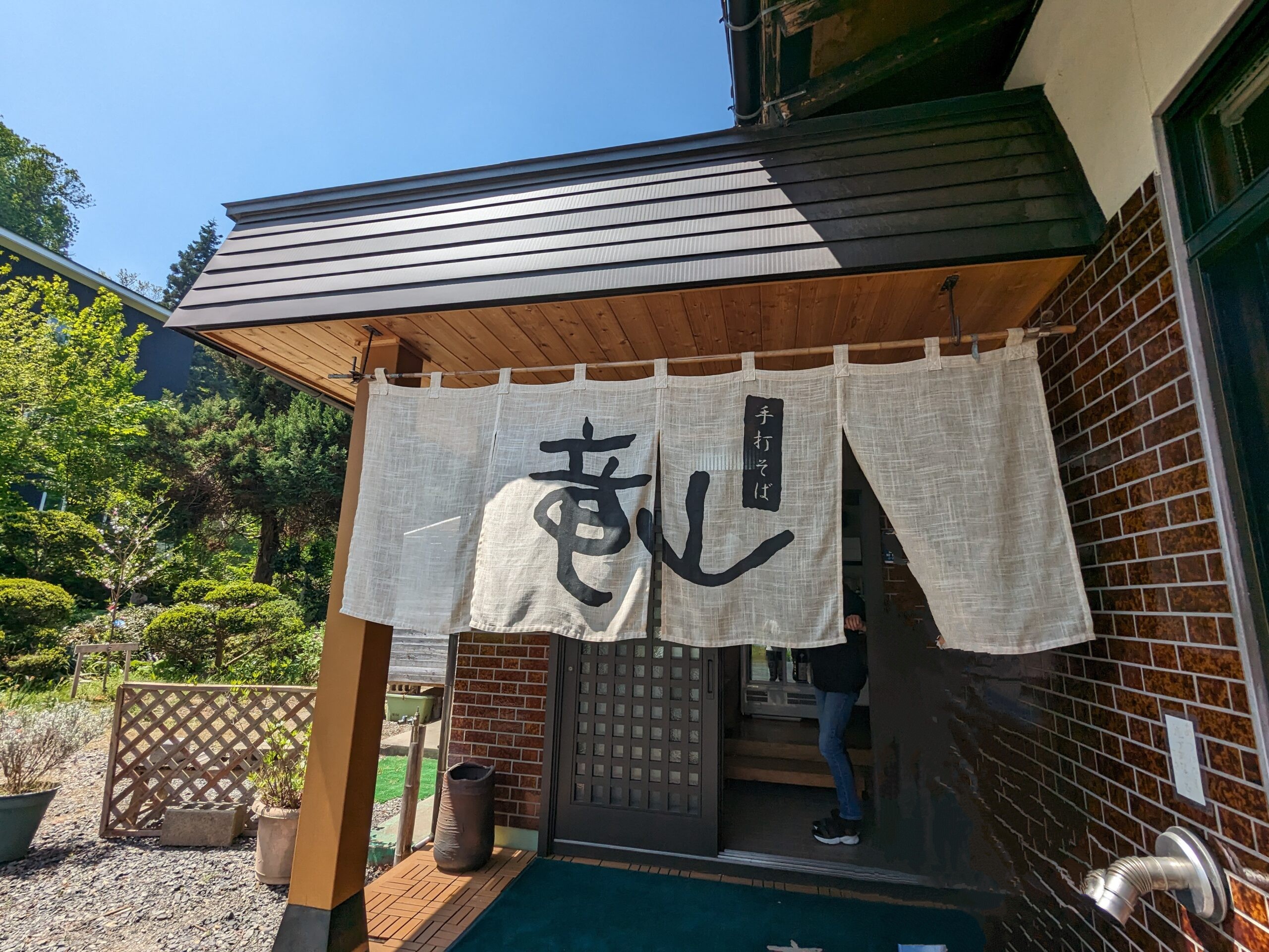 山形市『手打そば竜山』の店舗入り口。暖簾に筆文字で「竜山」の文字